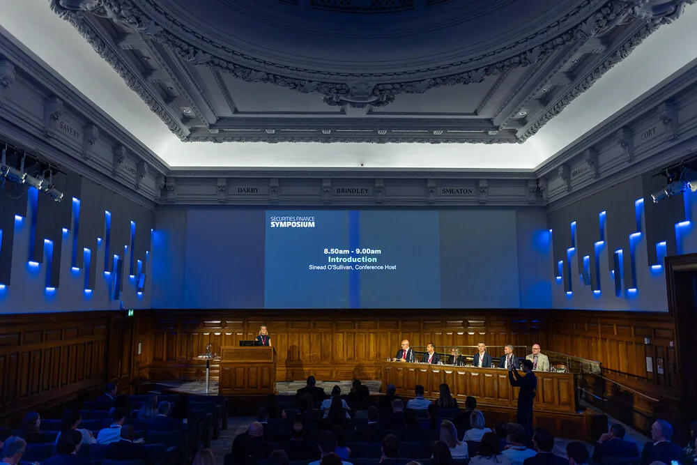 Sinead O'Sullivan opening the Securities Finance Symposium from the lectern, full panel and audience in view