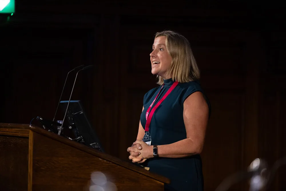 Sinead O'Sullivan under stage lighting at the lectern